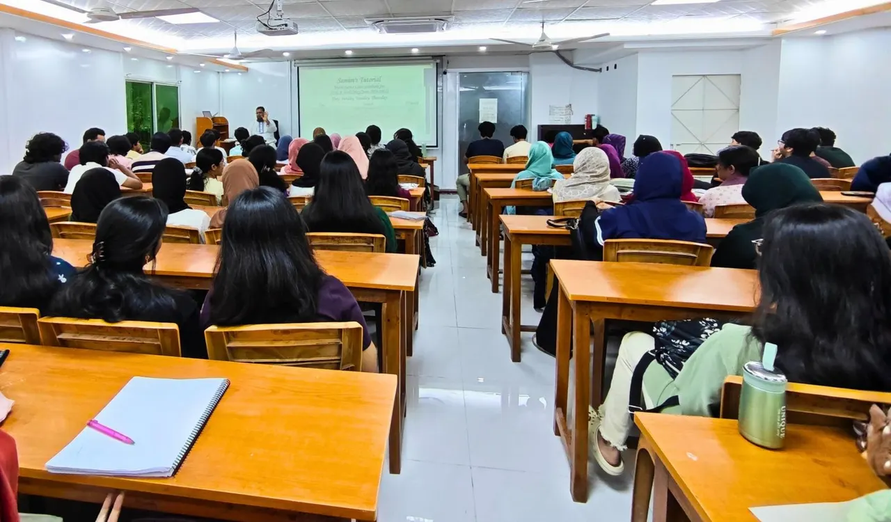 A large classroom full of students facing the projector screen